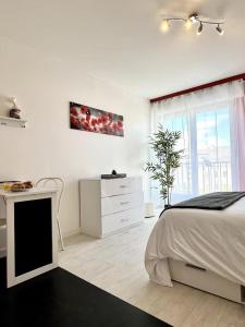 a white bedroom with a bed and a desk at Studio Le Ruby, Basel Freiburg Colmar Strasbourg in Huningue