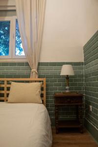 a bedroom with a bed and a table with a lamp at Montijo Garden - Alojamento Rural in Montijo