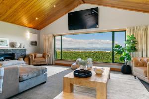 a living room with a couch and a large window at Spacious 5-Star Home with Pool in Taupo