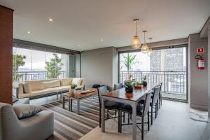 a living room with a table and a couch at Piscina no Rooftop! Studio a 3min do Metrô República in Sao Paulo