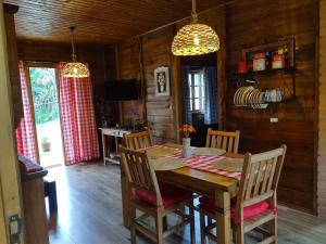 a dining room with a wooden table and chairs at Recanto Sol Maior - Casa Lírio in Sapucaí-Mirim