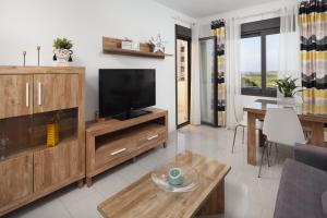 TV a/nebo společenská místnost v ubytování Playa Marinsa Beach piscina y padel