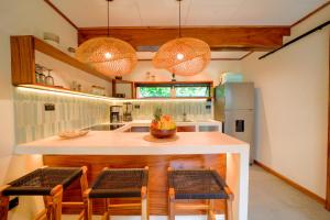 a kitchen with a counter with chairs and a island at Wabi Sabi Hana in Punta Uva