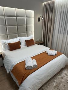 Un dormitorio con una cama grande con toallas. en Glenis Luxury Apartment, en Durrës