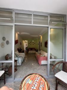 un salon avec une grande paroi en verre dans l'établissement Apartamento Pé na Areia Guarujá Pitangueiras, à Guarujá