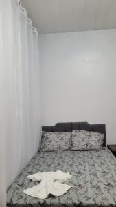a bed in a room with a white wall at Hotel Cristal in Barcarena +5 photos