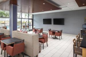 a dining room with tables and chairs and televisions at Holiday Inn Express & Suites Phoenix West - Buckeye by IHG in Buckeye