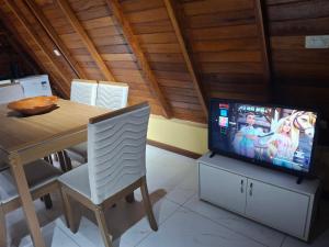 Uma TV ou centro de entretenimento em Chalé dos Campos