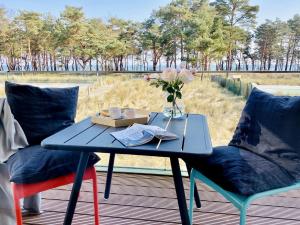 Ferienwohnung Proraloft 6 im Haus Prora Düne 7 في بينز: طاولة وكرسيين مع إناء من الزهور