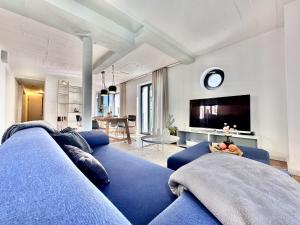 a living room with a blue couch and a tv at Ferienwohnung Dünenloft 7 im Haus Düne 7 Prora in Binz