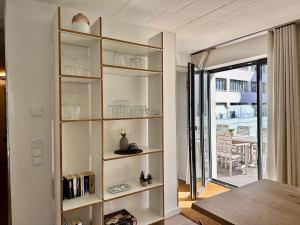 a room with glass shelves and a door to a patio at Ferienwohnung Dünenloft 7 im Haus Düne 7 Prora in Binz +33 photos