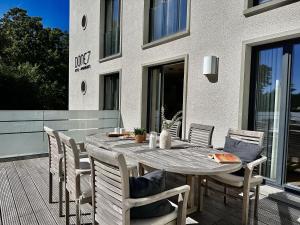 a wooden table and chairs on a patio at Ferienwohnung Dünenloft 7 im Haus Düne 7 Prora in Binz