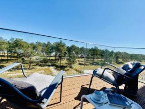 einen Balkon mit 2 Stühlen und einem Tisch mit einem Laptop in der Unterkunft Ferienwohnung Strandloft 12 im Haus Düne 7 Prora in Binz