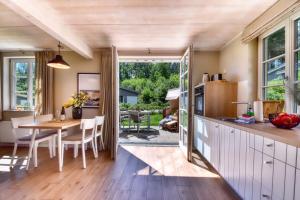 Una cocina y un comedor con mesa y sillas. en Ferienhaus Inselliebe 02 Feriendorf Klein Stresow Rügen by ruyastay, en Putbus