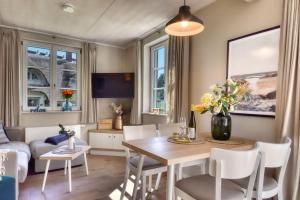 Una sala de estar con una mesa y sillas y un sofá. en Ferienhaus Inselliebe 02 Feriendorf Klein Stresow Rügen by ruyastay, en Putbus 8 fotos más