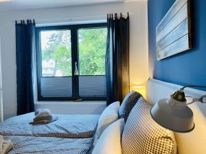 a bedroom with a bed with a lamp and a window at Ferienwohnung Strandkorb & Mee h r Parkvillen Carlota und Candela Baabe in Baabe