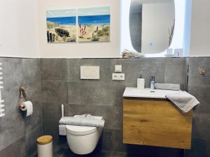 a bathroom with a toilet and a sink and a mirror at Ferienwohnung Strandkorb & Mee h r Parkvillen Carlota und Candela Baabe in Baabe +13 photos