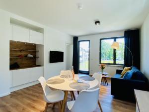 a kitchen and living room with a table and chairs at Ferienwohnung Strandläufer Parkvillen Carlota und Candela Baabe in Baabe