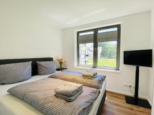 a bedroom with two beds and a flat screen tv at Ferienwohnung Strandläufer Parkvillen Carlota und Candela Baabe in Baabe