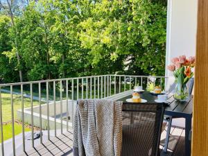 a table with a vase of flowers on a balcony at Ferienwohnung Strandläufer Parkvillen Carlota und Candela Baabe in Baabe
