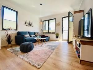 a living room with a blue couch and a tv at Ferienwohnung Strandloper Parkvillen Carlota und Candela Baabe in Baabe