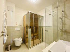 a bathroom with a glass shower and a toilet at Ferienwohnung Strandloper Parkvillen Carlota und Candela Baabe in Baabe +14 photos