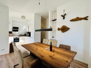 a kitchen and dining room with a wooden table at Ferienwohnung Sonnendeck Parkvillen Carlota und Candela Baabe in Baabe