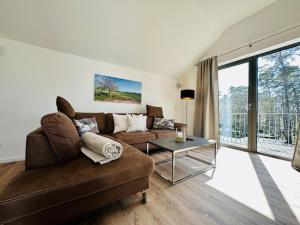 a living room with a couch and a table at Ferienwohnung Sonnendeck Parkvillen Carlota und Candela Baabe in Baabe
