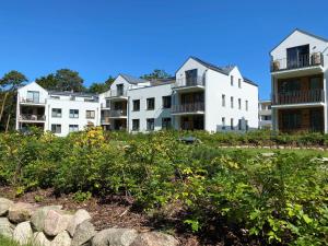 a row of white apartment buildings on a hill at Ferienwohnung Sonnendeck Parkvillen Carlota und Candela Baabe in Baabe