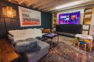 a living room with a couch and a tv at Family Pocono Gem by the lake with private sauna, hot tub, and huge game room in Arrowhead Lake