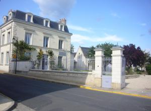 a large white building with a white fence on the side of the road at La Dixmeresse in Restigné