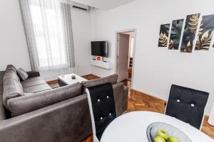a living room with a couch and a table at Apartman DRAGIN SAN in Subotica