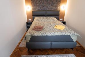 a bed in a small room with two towels on it at Apartman DRAGIN SAN in Subotica