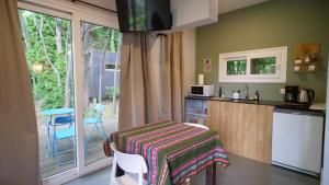 a kitchen with a counter and a table and a kitchen with a window at Mandarina suites in Tandil