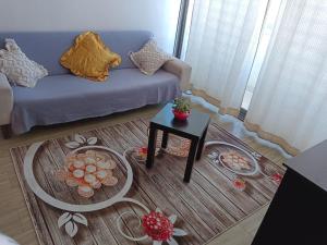 a living room with a blue couch and a table at Dpto Calama Centro in Calama