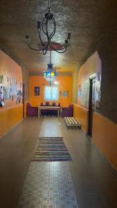 a hallway with a room with yellow walls and a chandelier at Guest house familly in Hassilabied
