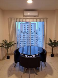 Una mesa y sillas en una habitación con una ventana grande. en Bahiaxdia Premium, en Bahía Blanca