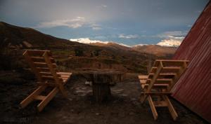 two chairs sitting next to a table with mountains at Illamama in La Paz
