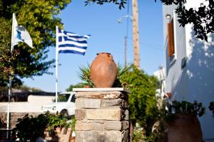 a pot sitting on top of a stone pillar with flags at Margarita Studios in Parikia