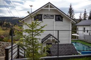 a house with a tree in front of it at Villa Olexandr&Matvii in Bukovel