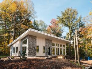 a house in the woods with trees at Chalet Eau, style Lake house à Tremblant in Lac-Superieur