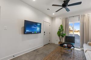 ein Wohnzimmer mit einem Flachbildfernseher an der Wand in der Unterkunft Bourbon House King Bed Luxury Amenities Fast WiFi in Lafayette