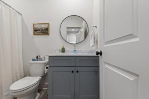 ein Badezimmer mit Waschbecken, Toilette und Spiegel in der Unterkunft Bourbon House King Bed Luxury Amenities Fast WiFi in Lafayette