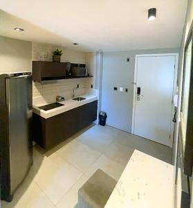 Una cocina con refrigerador de acero inoxidable en una habitación. en Flat completo no Infinity at the sea, en João Pessoa