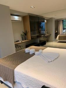 Un dormitorio con una cama grande con toallas. en Flat completo no Infinity at the sea, en João Pessoa