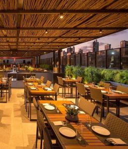 Un restaurante con mesas y sillas de madera y una cocina. en Flat completo no Infinity at the sea, en João Pessoa