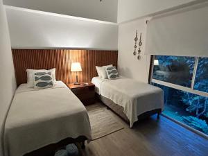 a hotel room with two beds and a window at Playa Hermosa, Mistico, Surf, Bike, Hike, 4 Hab, Lagos, Familia in Jacó