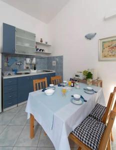 a dining room with a table and chairs and a kitchen at Apartment Blue in Igrane