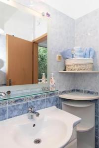 a bathroom with a sink and a mirror and a toilet at Apartment Blue in Igrane +17 photos