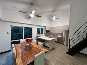 a kitchen and dining room with a wooden table and chairs at Playa Hermosa, Mistico, Surf, Bike, Hike, 4 Hab, Lagos, Familia in Jacó